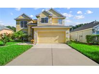 Charming two-story home with a manicured lawn and a two-car garage, under a sunny blue sky at 7711 Nottinghill Sky Dr, Apollo Beach, FL 33572