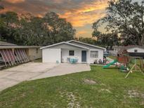 Charming single-story home featuring a manicured lawn and outdoor play area at 8701 N Packwood Ave, Tampa, FL 33604