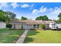 Charming single-story home featuring a well-maintained lawn and stone accents under a sunny, blue sky at 901 Strawberry Ln, Brandon, FL 33511