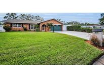 Charming brick home featuring lush green lawn, well-manicured landscaping, and a convenient garage at 11236 116Th St, Largo, FL 33778
