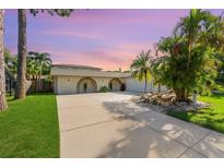 Inviting home featuring a barrel archway and lush tropical landscaping creating a serene and picturesque setting at 218 N Bay Hills Blvd, Safety Harbor, FL 34695