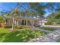 Charming two-story home with landscaped yard, inviting porch, and detached two-car garage at 2803 W Morrison Ave, Tampa, FL 33629