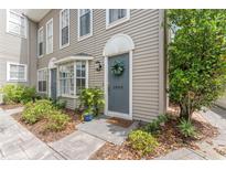 Charming townhouse featuring a stylish gray door with a floral wreath and well-maintained landscaping at 2809 W Platt St # 6, Tampa, FL 33609