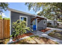 Charming home featuring a bright blue front door, gray siding, and a well-maintained landscaped area at 2859 38Th N Ave, St Petersburg, FL 33713