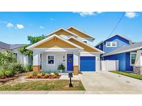 Charming home featuring a colorful front door, landscaped yard, and a one car garage at 2918 N 21St St, Tampa, FL 33605