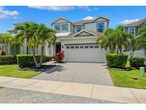 Beautiful two-story home boasts a paved driveway, a two-car garage, and tropical landscaping at 315 Blackrock Ln, Apollo Beach, FL 33572