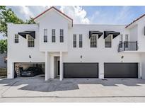 Modern townhomes feature multiple garage doors, black awnings, and a terracotta roof at 3210 W Horatio St # 9, Tampa, FL 33609