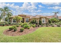 Beautiful single-story home featuring stone accents, a tile roof, and lush landscaping at 33744 Americana Ave, Dade City, FL 33525