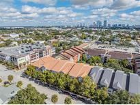 A captivating aerial view of a neighborhood with a city skyline in the background on a sunny day at 410 S Armenia Ave # 926, Tampa, FL 33609