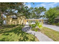 Charming single-story home with a well-manicured lawn and paved walkway to the front door at 4521 S Cooper Pl, Tampa, FL 33611