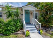Charming home featuring a blue front door, well-kept landscaping, and inviting entrance steps at 811 W Peninsular St, Tampa, FL 33603