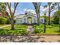 Charming single-story home with a landscaped front yard, sidewalk, and inviting yellow front door at 842 S Boulevard, Tampa, FL 33606