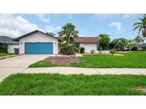Charming single-story home with a lush lawn and inviting blue garage door, perfect for curb appeal at 8635 Chadwick Dr, Tampa, FL 33635