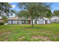 Charming single-story home with mature tree, lovely landscaping, and brick accents at 11001 Ridgedale Rd, Temple Terrace, FL 33617