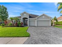 Charming single-story home featuring a three-car garage and meticulously landscaped front yard at 11325 78Th E St, Parrish, FL 34219