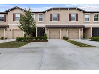 Inviting townhomes showcasing attached garages, landscaped yards, and neutral stucco exteriors under a cloudy sky at 11916 Castine St, New Port Richey, FL 34654