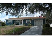 Charming single-story home with blue siding, white trim, and an attached two-car garage at 12411 Brookside St, Spring Hill, FL 34609