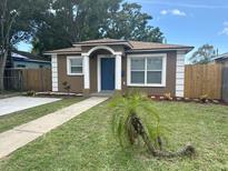 Charming single-story home featuring a well-manicured lawn, blue front door, and inviting curb appeal at 1309 29Th S St, St Petersburg, FL 33712