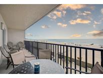 Relax on the balcony with a table and chairs overlooking the beach with ocean views at 14300 Gulf Blvd # 104, Madeira Beach, FL 33708