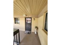 Inviting condo entrance with storm door, welcome mat and planter at 2685 Sabal Springs Cir # 202, Clearwater, FL 33761