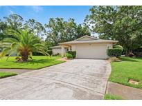 Charming single-story home featuring a well-manicured lawn and a two-car garage at 2875 Lomond Dr, Palm Harbor, FL 34684