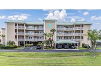 A charming condo building with a well-manicured lawn and covered parking at 399 150Th Ave # 315, Madeira Beach, FL 33708