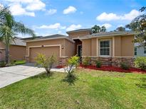 Charming single-story home with a well-manicured lawn and stone accents at 4079 Pacente Loop, Wesley Chapel, FL 33543