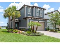 Charming two-story home featuring a two-car garage, lush landscaping, and elegant architectural details at 4644 San Martino Dr, Wesley Chapel, FL 33543