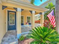 Charming front porch with decorative door, blue accents, and beautiful landscaping at 621 Winterside Dr, Apollo Beach, FL 33572