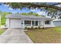 Charming single-story home with a well-maintained yard, covered porch, and attached garage at 9936 62Nd N St, Pinellas Park, FL 33782