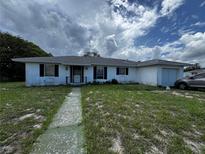 Modest single-story home featuring a driveway and front lawn needing tender loving care at 1106 Trellis Ave, Spring Hill, FL 34606