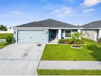 Charming single-story home features a well-manicured lawn and attached two-car garage at 11940 Stone Pine St, Riverview, FL 33569