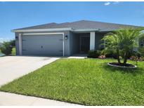 Charming single-story home featuring a well-maintained lawn, a two-car garage, and tidy landscaping at 11940 Stone Pine St, Riverview, FL 33569