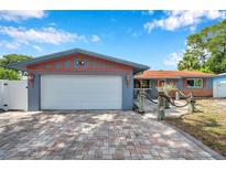 Charming single-story home featuring an attached garage and a brick driveway leading to a well-maintained front yard at 1710 Townsend St, Clearwater, FL 33755