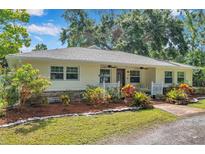 Charming single-story home featuring manicured landscaping, warm exterior, and a welcoming front porch at 2140 Bow Ln, Safety Harbor, FL 34695