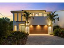 Contemporary two-story home featuring a statement wood garage door, manicured landscaping, and modern architectural details at 2803 W Aquilla St, Tampa, FL 33629
