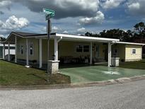 Charming single Gathering home featuring covered carport, attractive curb appeal, and well-manicured landscaping at 35020 Colony Hills Dr, Zephyrhills, FL 33541