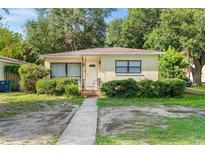 Charming single-story home featuring a well-maintained front yard with mature landscaping and a welcoming entryway at 3622 W Mullen Ave, Tampa, FL 33609