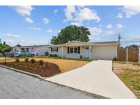 Charming single-story home featuring a well-manicured lawn, fresh mulch, and a long driveway at 3850 Carioca Rd, Holiday, FL 34691