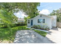 Charming single-story home with a blue front door, landscaped yard, and a concrete driveway at 4044 56Th N Ave, St Petersburg, FL 33714