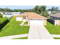 Charming single-story home with a well-manicured lawn and a two-car garage at 4928 Timber Way, Zephyrhills, FL 33542