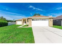 Charming single-story home with a manicured lawn and a two-car garage at 4928 Timber Way, Zephyrhills, FL 33542