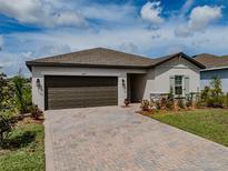 Charming one-story home featuring a brick driveway and professionally landscaped front yard at 5329 Senza Trl, Palmetto, FL 34221