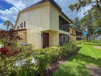 Inviting exterior view of the property showcasing well-maintained landscaping and a charming facade with a screen enclosed porch at 5785 Gardens Dr, Sarasota, FL 34243