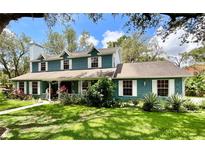 Charming two-story home featuring a well-manicured lawn and beautiful landscaping at 8834 Whispering Oaks Trl, New Port Richey, FL 34654