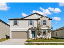 Charming two-story home features a well-manicured lawn and a two-car garage at 8918 Parsons Hill Blvd, Wesley Chapel, FL 33545