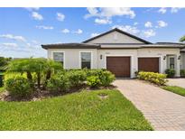 Charming home featuring a well-manicured lawn, a brick driveway, and a two-car garage at 10282 Echo Dock Loop, San Antonio, FL 33576