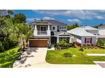 Charming two-story home features a well-manicured lawn, inviting front porch, and attached two-car garage at 10399 Boyette Brook St, Riverview, FL 33569