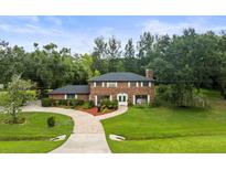 Beautiful brick home featuring lush landscaping, a brick driveway, and a well-maintained lawn at 12603 Corral Rd, Tampa, FL 33626