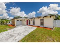 Charming single-story home with stone accents, a well-maintained lawn, and a driveway at 12877 Palm Dr, Largo, FL 33774
